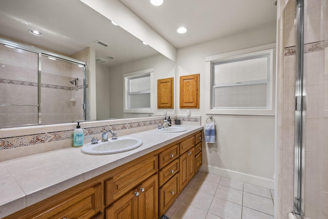 bathroom with vanity, a shower with shower door, and tile patterned floors