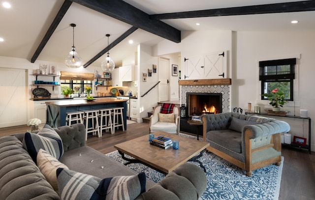 living room with sink, lofted ceiling with beams, dark hardwood / wood-style floors, and a tile fireplace