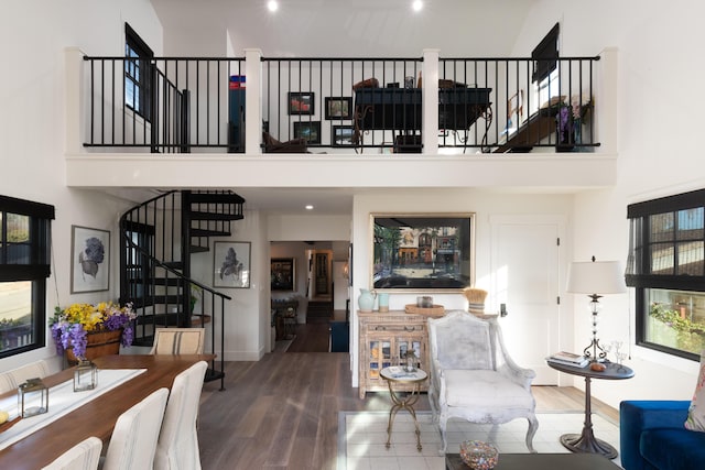 living room with hardwood / wood-style flooring and a towering ceiling