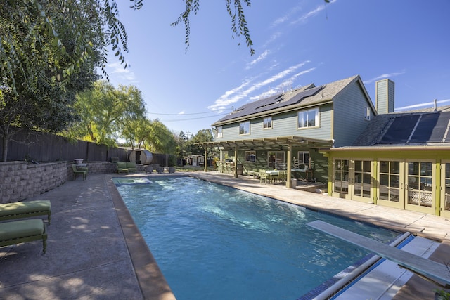 view of pool featuring a diving board, a pergola, a sunroom, and a patio area