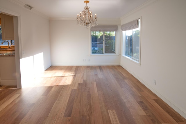 empty room with an inviting chandelier, sink, hardwood / wood-style flooring, and ornamental molding