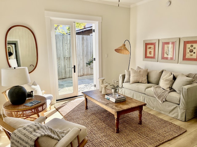 living room with french doors, ornamental molding, and light hardwood / wood-style floors