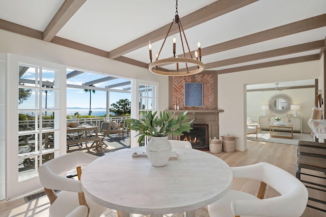 dining room featuring an inviting chandelier, light hardwood / wood-style flooring, and beam ceiling