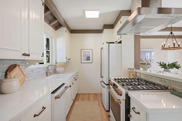 kitchen with white cabinetry, hanging light fixtures, sink, extractor fan, and white appliances