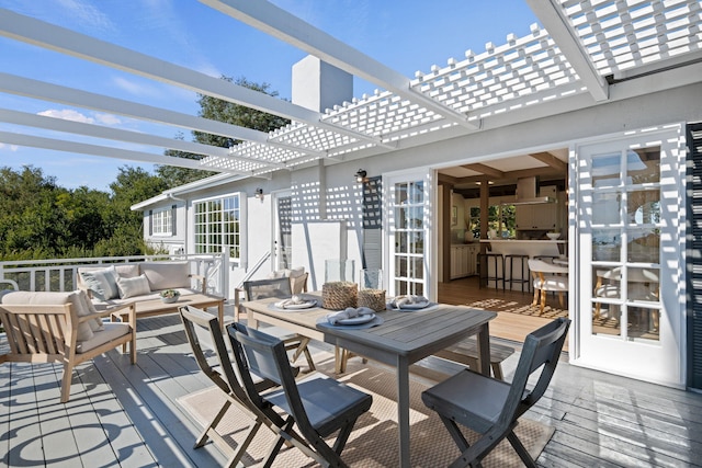 wooden deck featuring a pergola and an outdoor hangout area