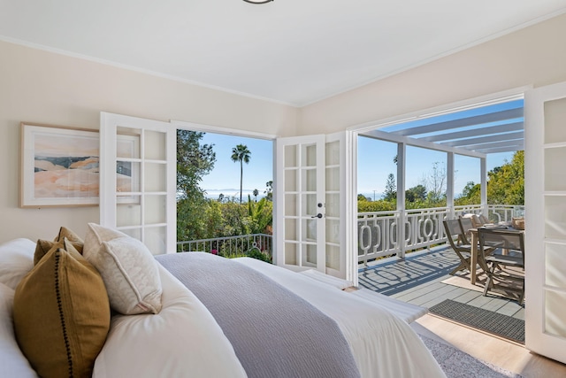 bedroom with crown molding, hardwood / wood-style floors, and access to outside