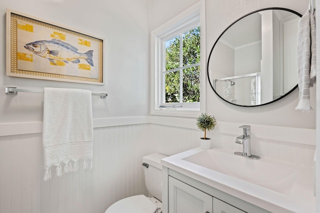 bathroom with vanity, a shower with door, and toilet