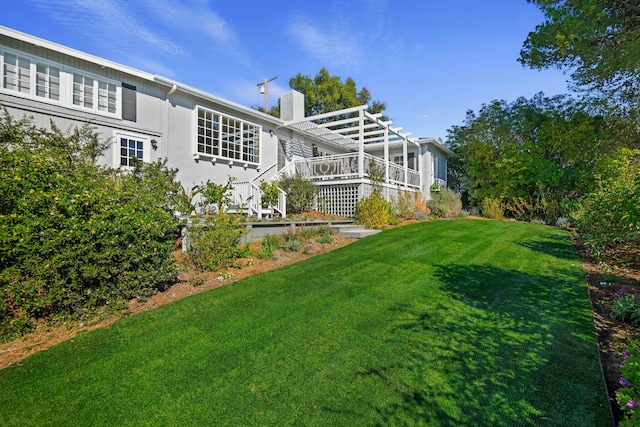 back of house with a lawn, a deck, and a pergola