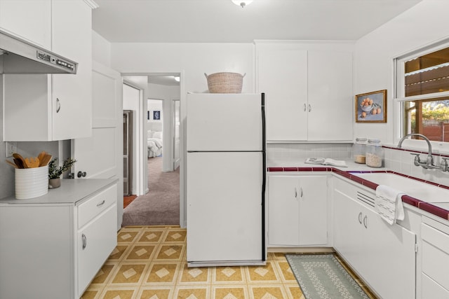 kitchen featuring white cabinetry, sink, tasteful backsplash, and white refrigerator