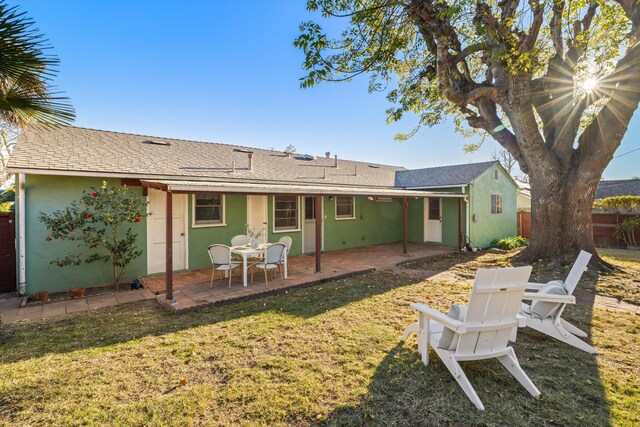 back of house with a patio area and a lawn