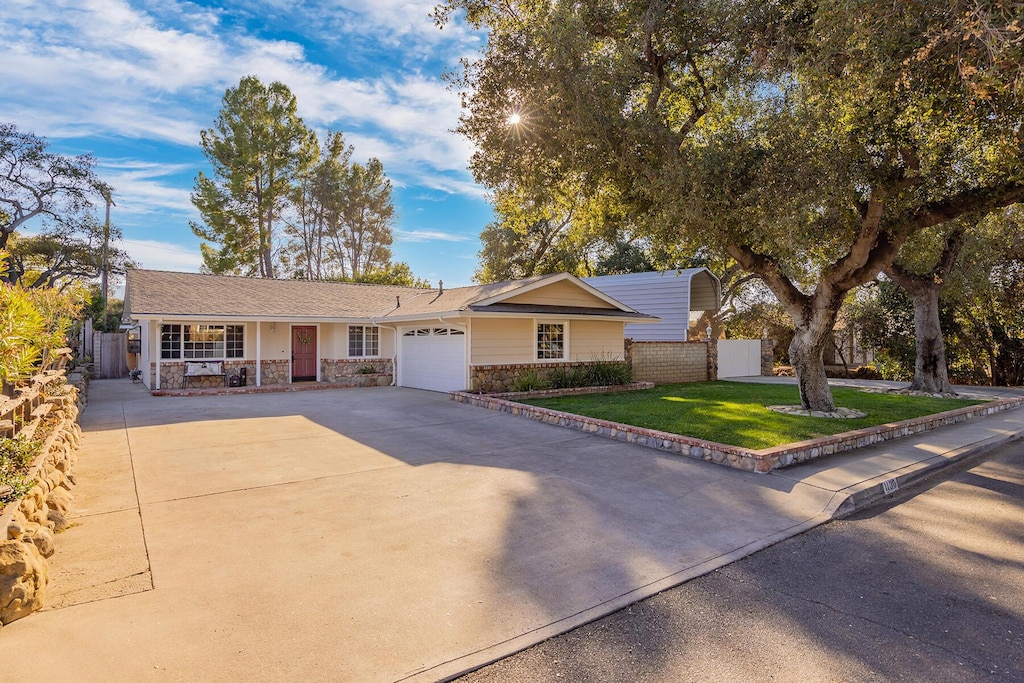 ranch-style house featuring a garage and a front yard