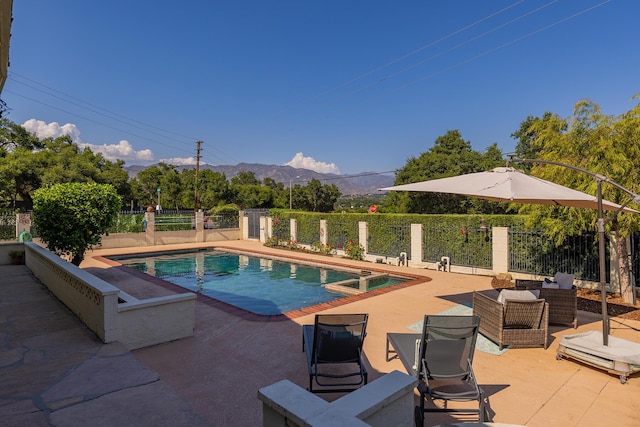 view of pool featuring outdoor lounge area, a mountain view, and a patio