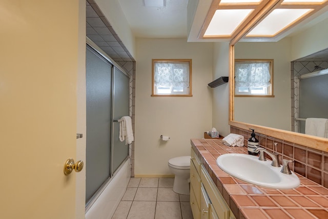 full bathroom featuring tile patterned flooring, a skylight, plenty of natural light, vanity, and toilet