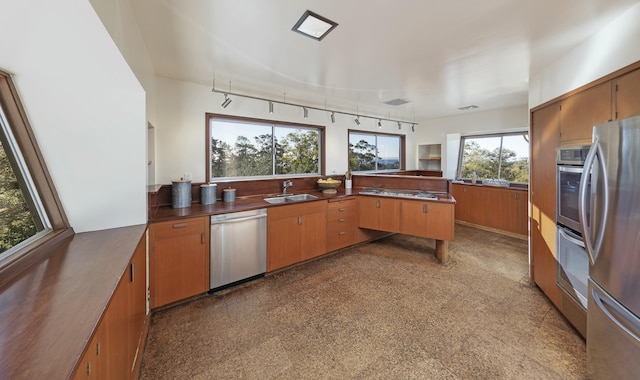 kitchen with appliances with stainless steel finishes, sink, and kitchen peninsula