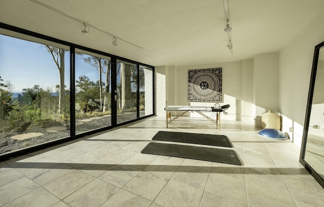 unfurnished sunroom featuring track lighting