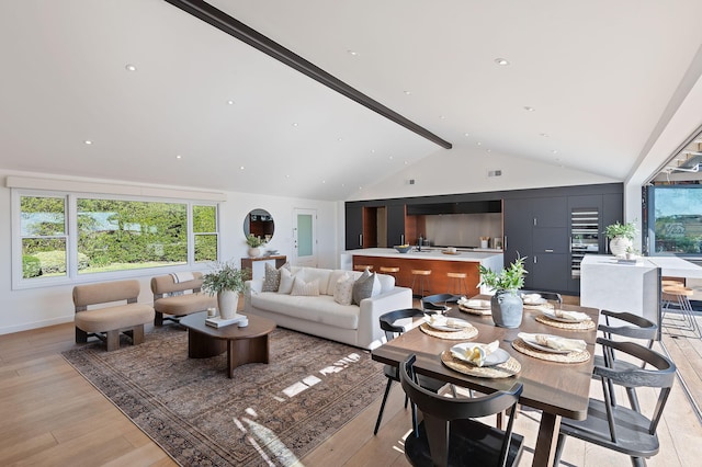 living room with lofted ceiling with beams and light hardwood / wood-style flooring