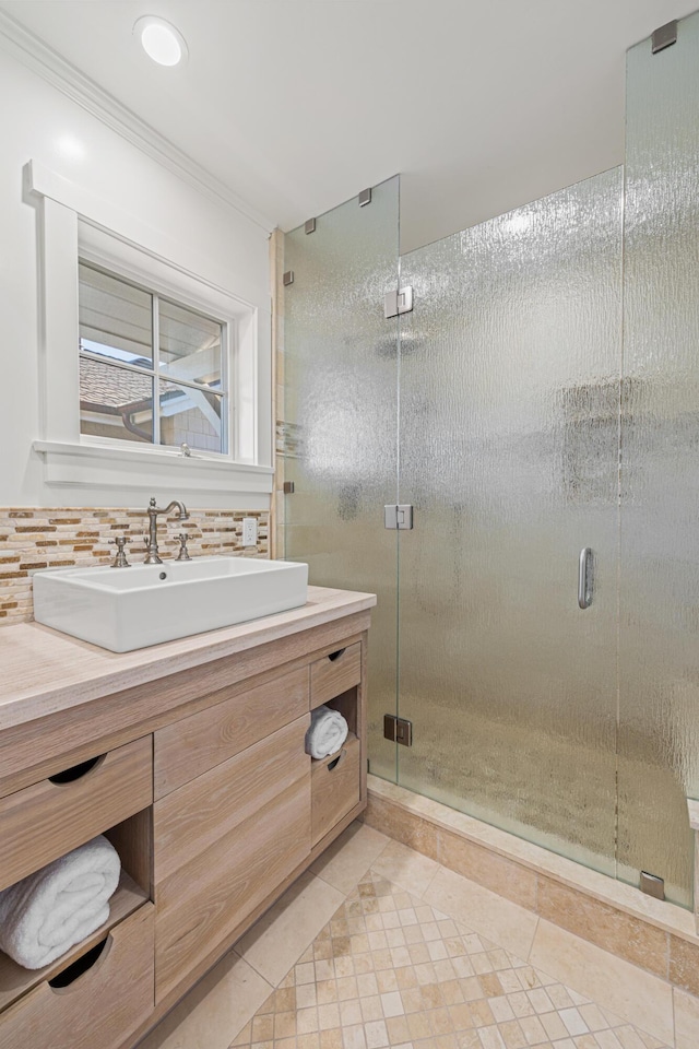 bathroom featuring crown molding, backsplash, an enclosed shower, vanity, and tile patterned floors