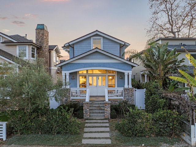 view of front of property with french doors and covered porch