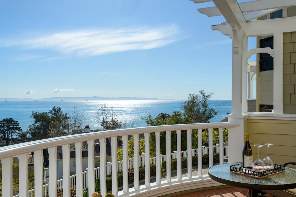 balcony featuring a water and mountain view