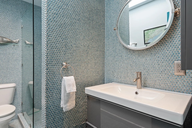 bathroom featuring vanity, tile walls, and toilet