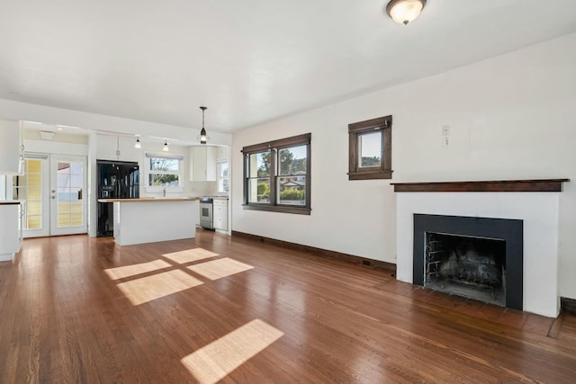 unfurnished living room with dark hardwood / wood-style floors and french doors