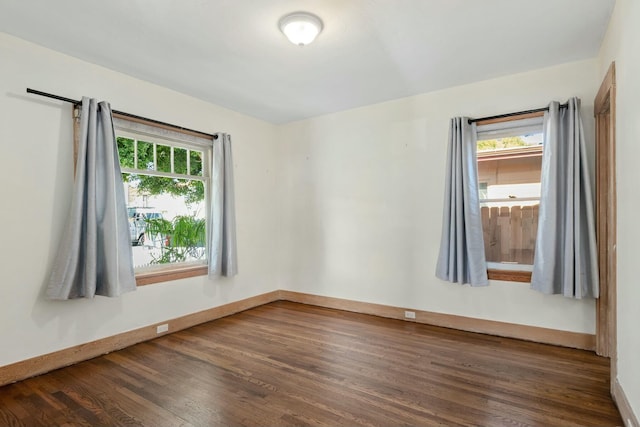 unfurnished room with dark wood-type flooring