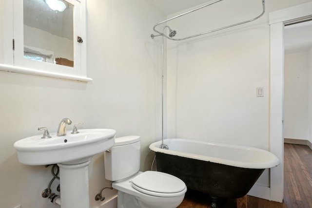 bathroom with wood-type flooring, shower / washtub combination, and toilet