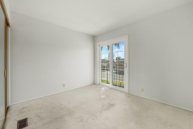 carpeted spare room featuring visible vents