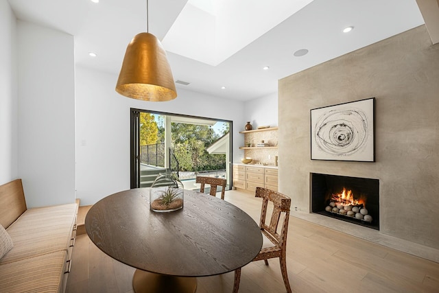 dining area with a high end fireplace and light hardwood / wood-style flooring