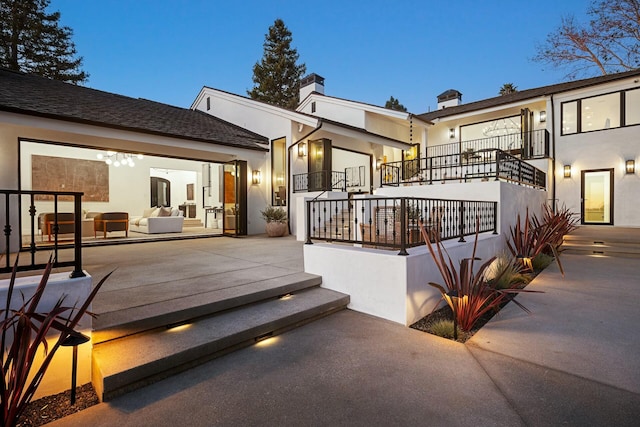 rear view of property with a patio area and a balcony