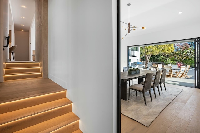 stairway featuring hardwood / wood-style floors and a notable chandelier