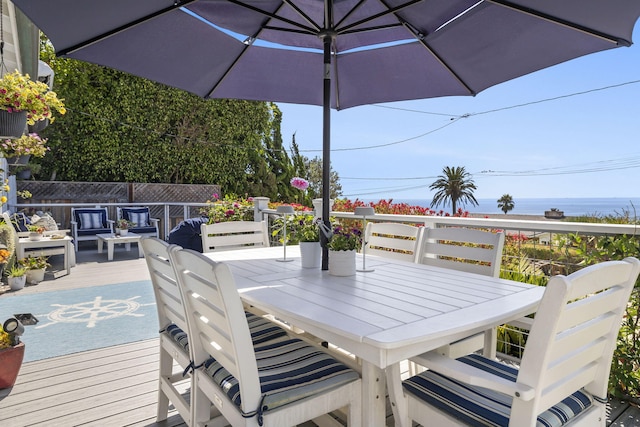 wooden deck featuring a water view and an outdoor living space