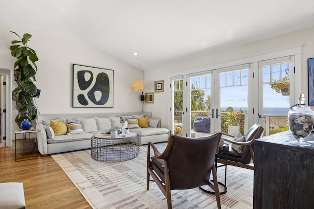 living room featuring french doors, vaulted ceiling, and light hardwood / wood-style flooring