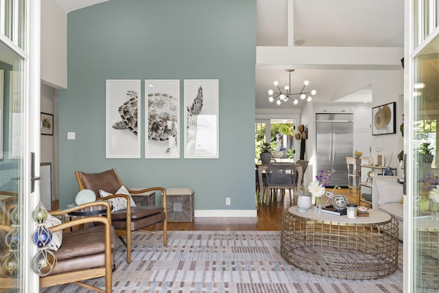 living room with hardwood / wood-style flooring, high vaulted ceiling, and an inviting chandelier