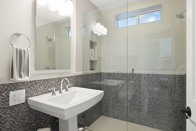 bathroom featuring walk in shower, sink, and backsplash