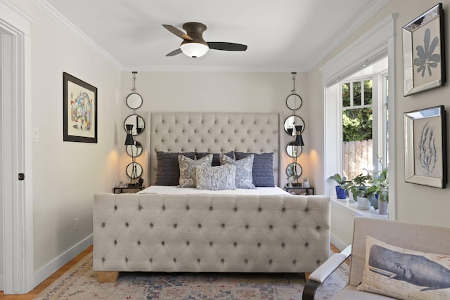 bedroom featuring hardwood / wood-style flooring, ornamental molding, and ceiling fan