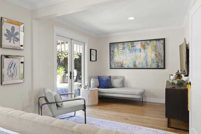 sitting room with crown molding, light hardwood / wood-style floors, and french doors