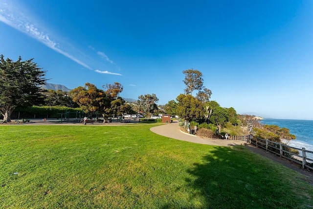 surrounding community featuring a lawn and a water view