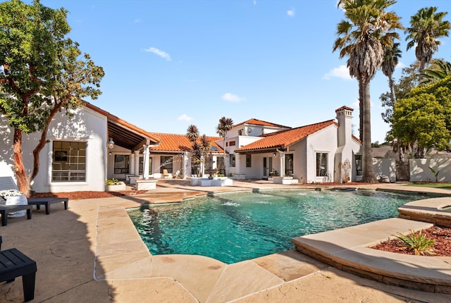 view of swimming pool with pool water feature and a patio