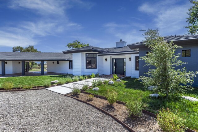 view of front of property featuring a front lawn and a carport