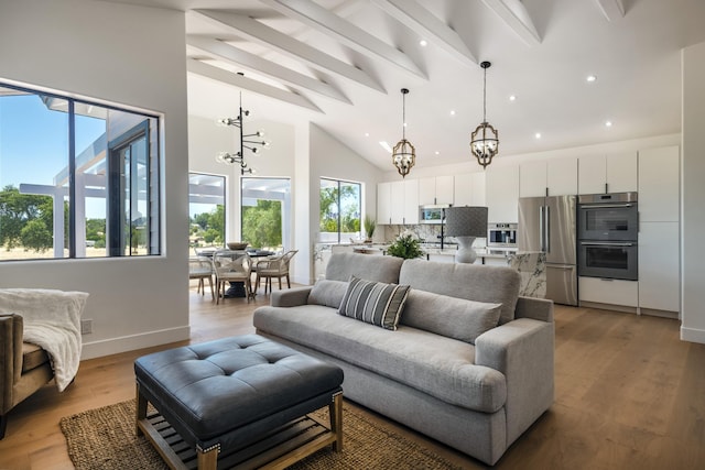 living room with hardwood / wood-style flooring, lofted ceiling with beams, and a chandelier