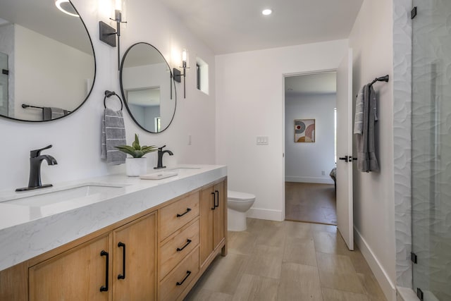 bathroom featuring vanity, an enclosed shower, and toilet