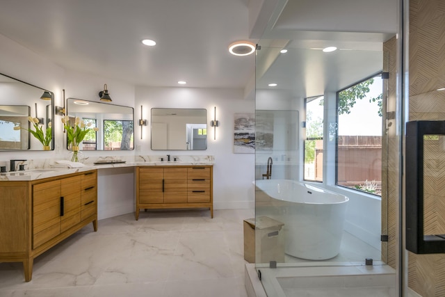 bathroom featuring a washtub, vanity, and plenty of natural light