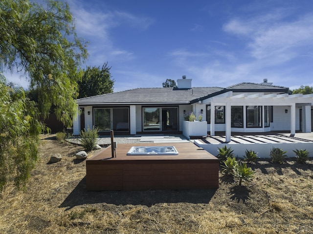 back of house featuring a pergola and a jacuzzi