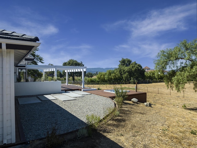 view of yard with a deck with mountain view, a pergola, and a patio