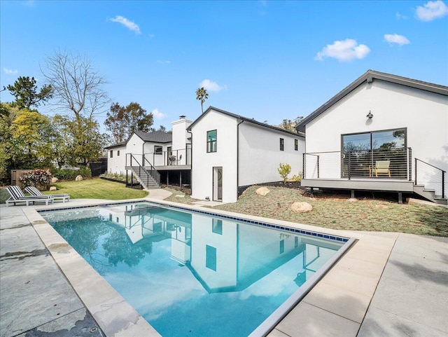 pool featuring stairs, a lawn, a patio area, and a wooden deck