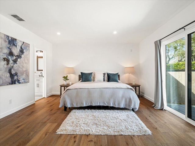 bedroom featuring access to exterior, wood finished floors, visible vents, and baseboards