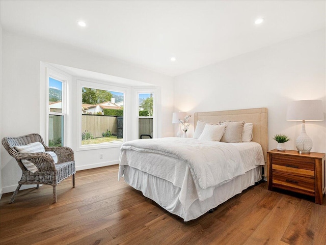 bedroom featuring baseboards, dark wood finished floors, and recessed lighting