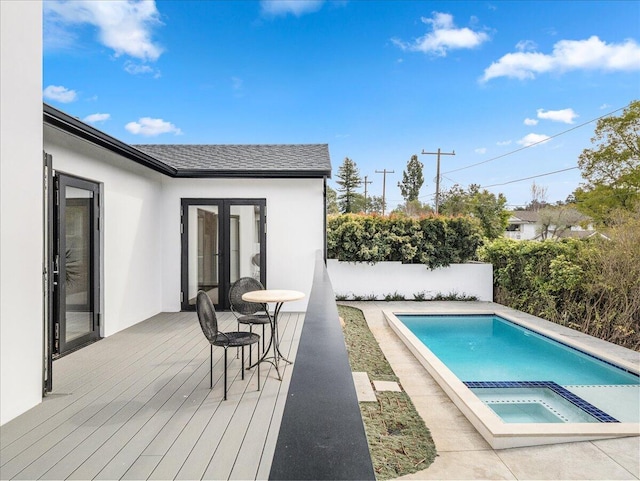 view of swimming pool featuring a fenced in pool, french doors, fence, an in ground hot tub, and a wooden deck