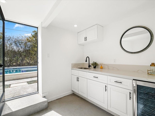 bar with baseboards, wine cooler, a wall of windows, a sink, and recessed lighting